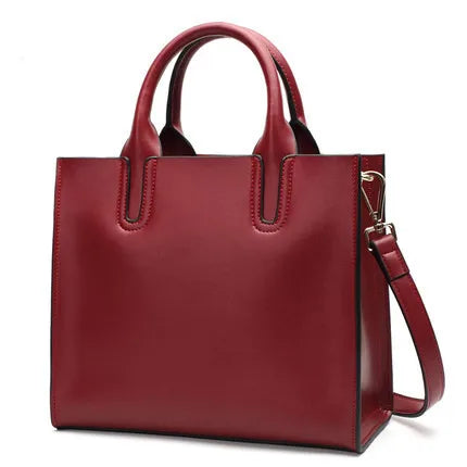 Red vintage leather tote bag with top handles, structured trunk style, and detachable shoulder strap.