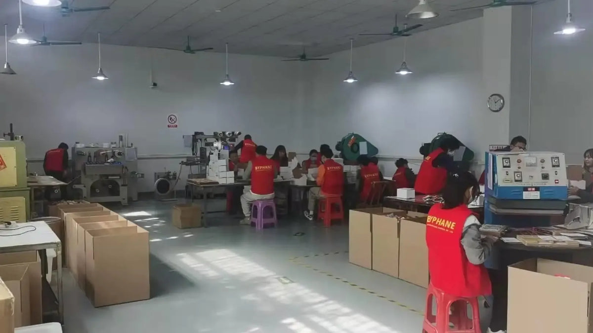 Manufacturing workshop interior with workers near equipment and boxes
