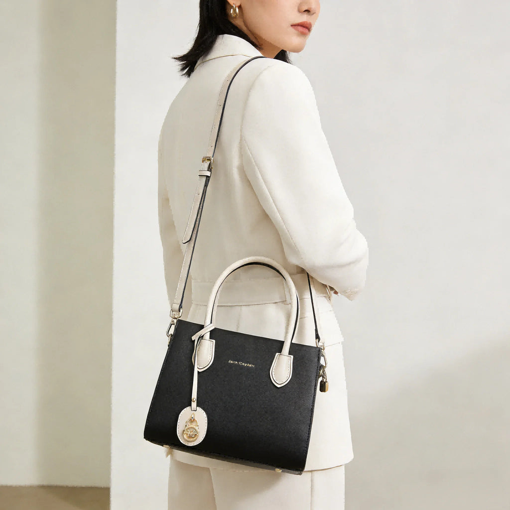 Black leather Jack Captain designer shoulder bag, two-tone tote with white handles and gold charm. Designer Handbags.