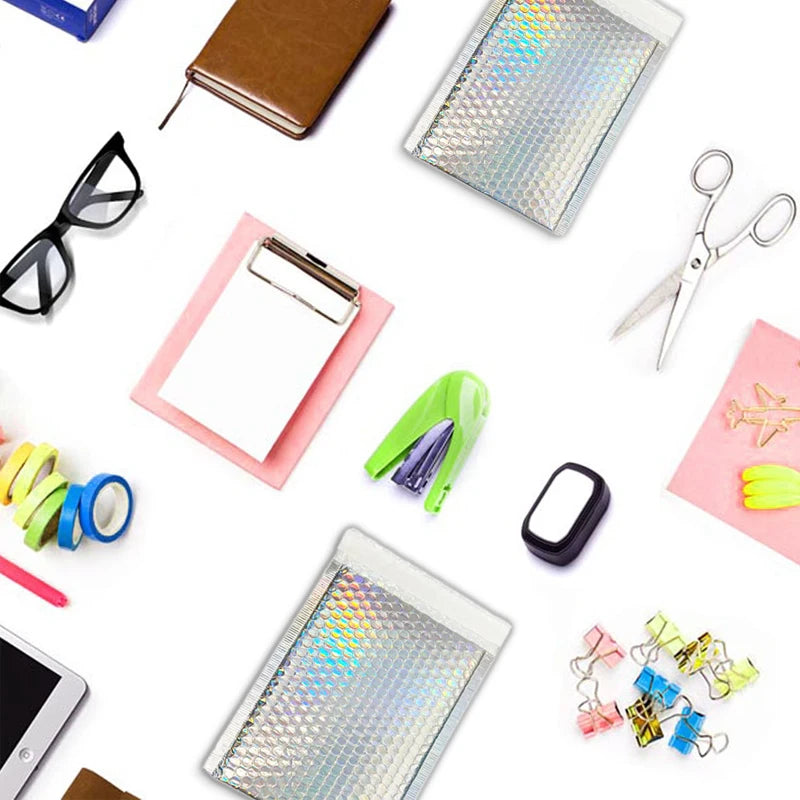Set of holographic bubble mailers laid out with office supplies