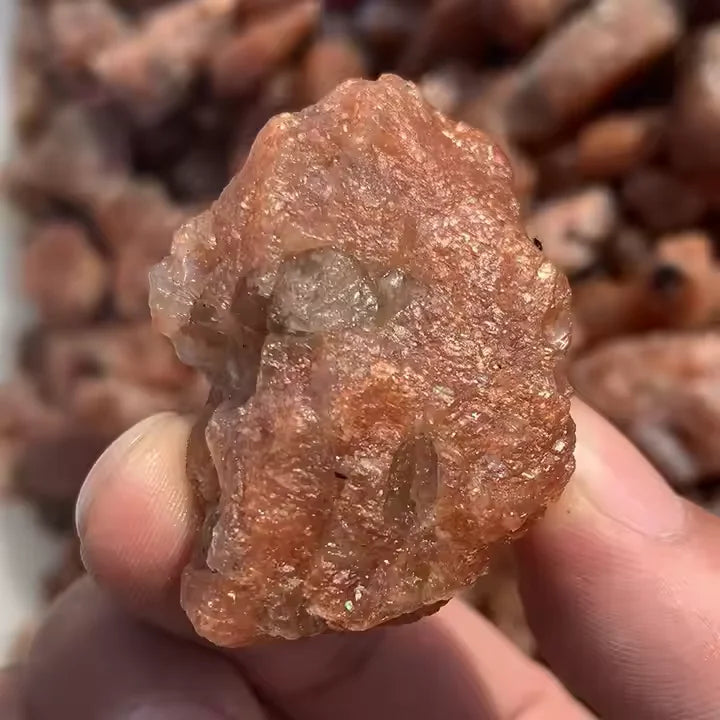 Raw golden sunstone quartz crystal, uneven rough edges held up
