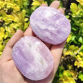 Kunzite palm stones two oval lavender gemstones held in a hand