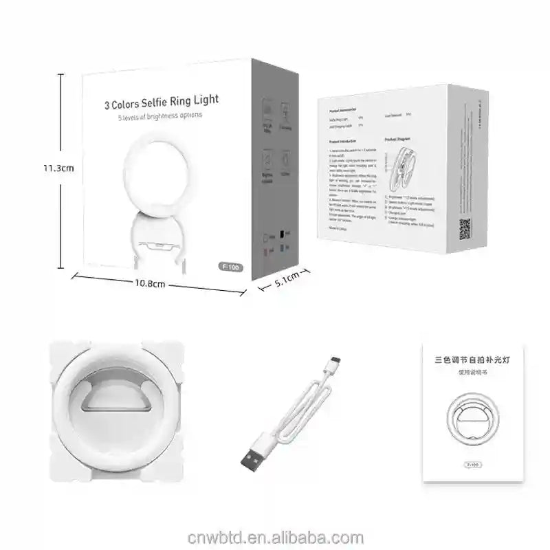 White selfie ring light, USB charging cable, and packaging box. Round, plastic light for smartphone photography.