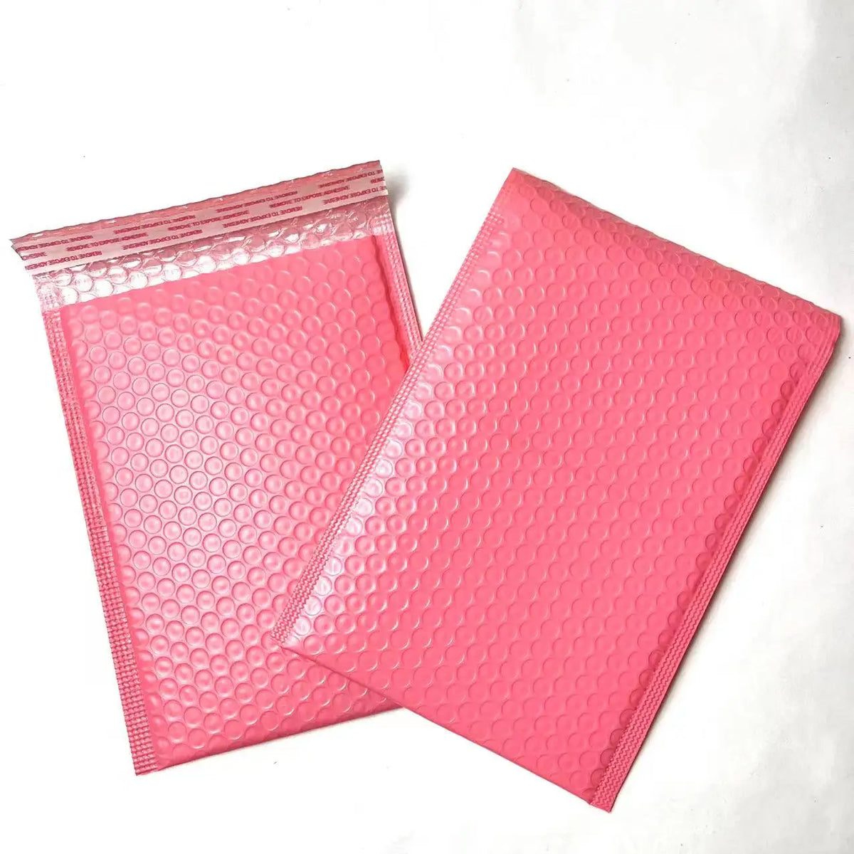 Pink bubble mailer shipping bags with raised bubble-texture poly surface.