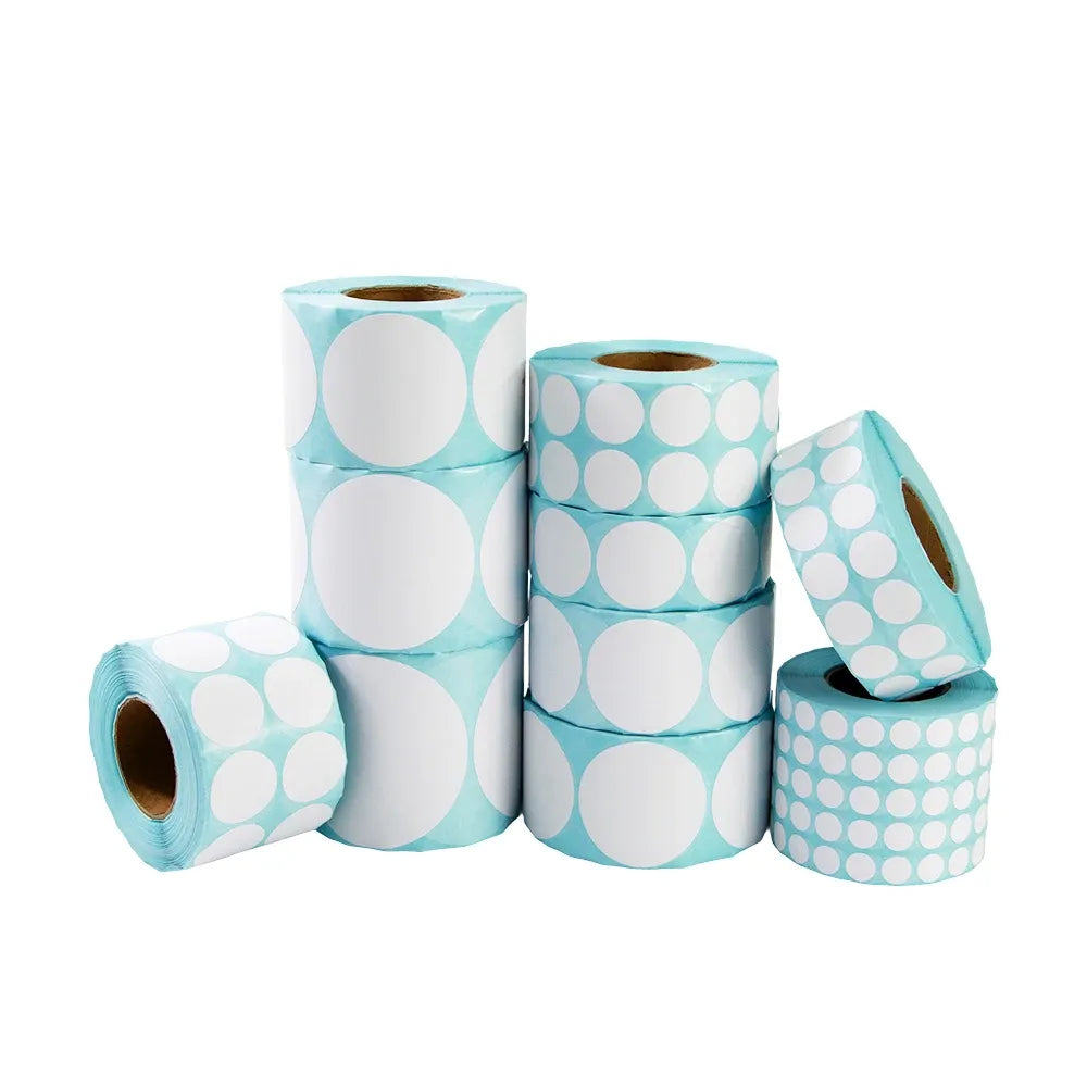 Stack of light blue thermal barcode label rolls with white circular patterns, adhesive