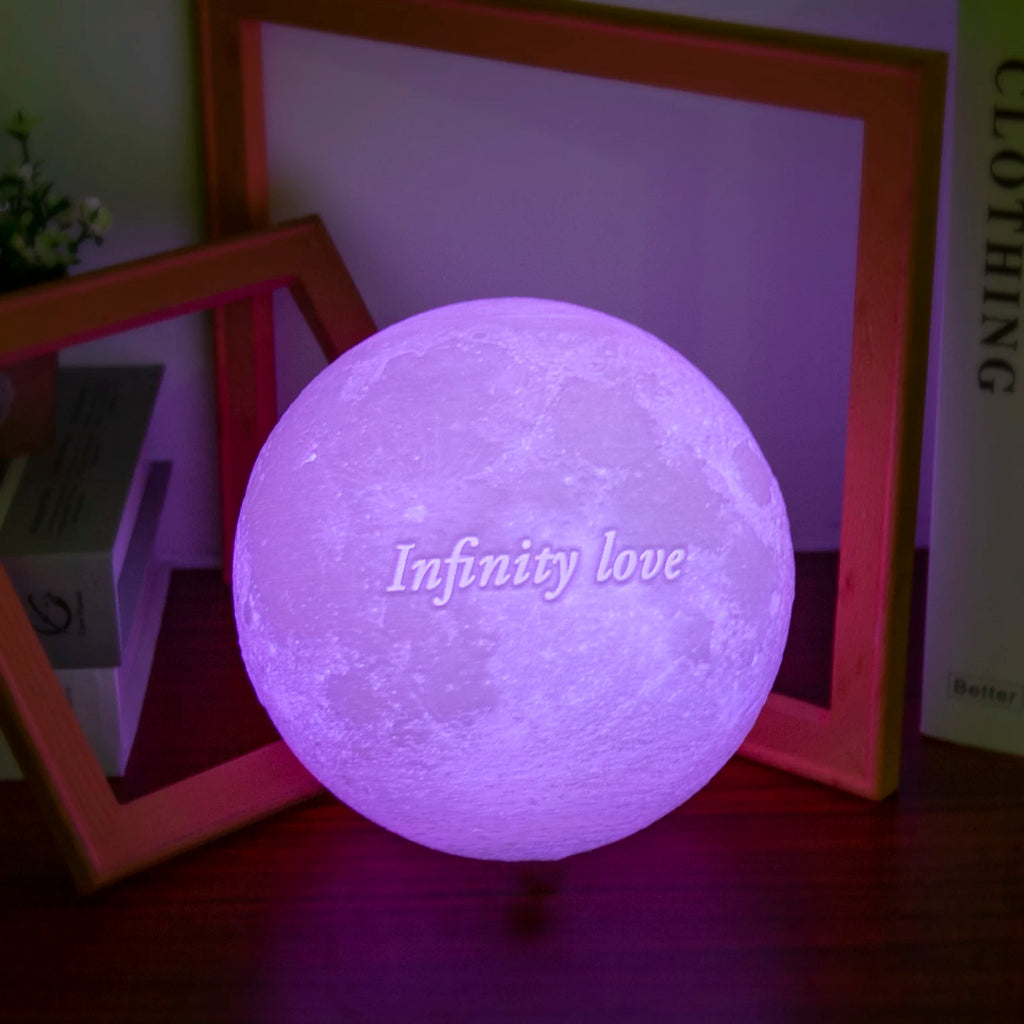 Round moon-shaped lamp glowing purple with the text "Infinity love," used as decorative ambient room lighting.