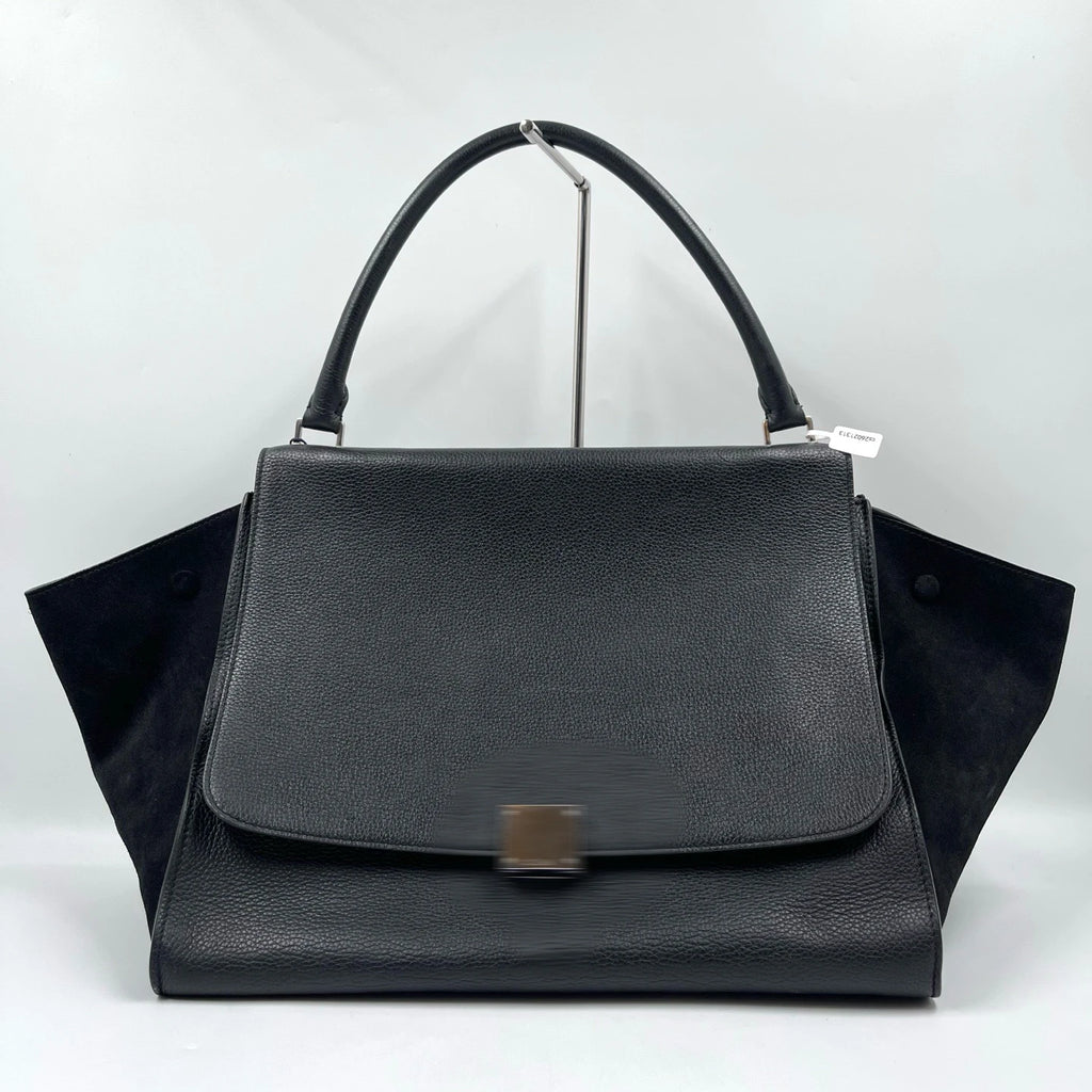 Classic black designer shoulder bag in lychee texture leather with vintage swing side panels and a single top handle.