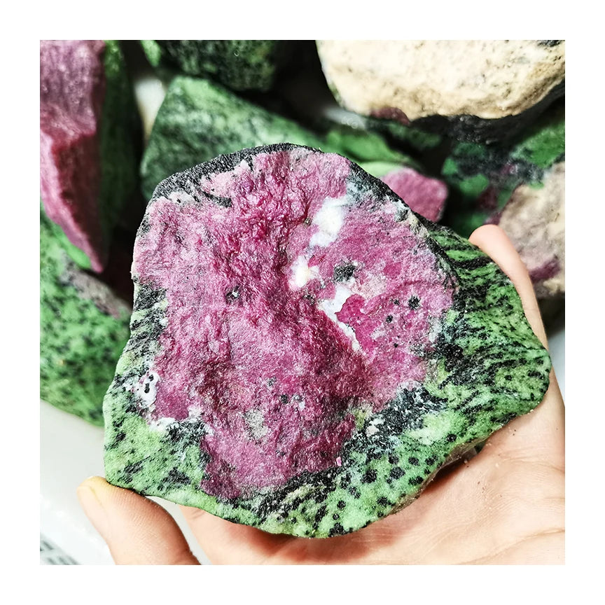 Rough red and green quartz healing stone with crystalline surface in hand