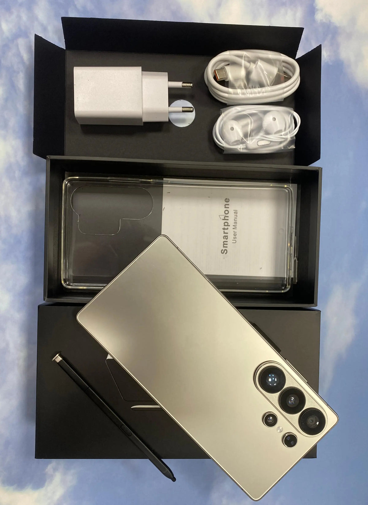 White smartphone and built-in pen with accessories in open box packaging