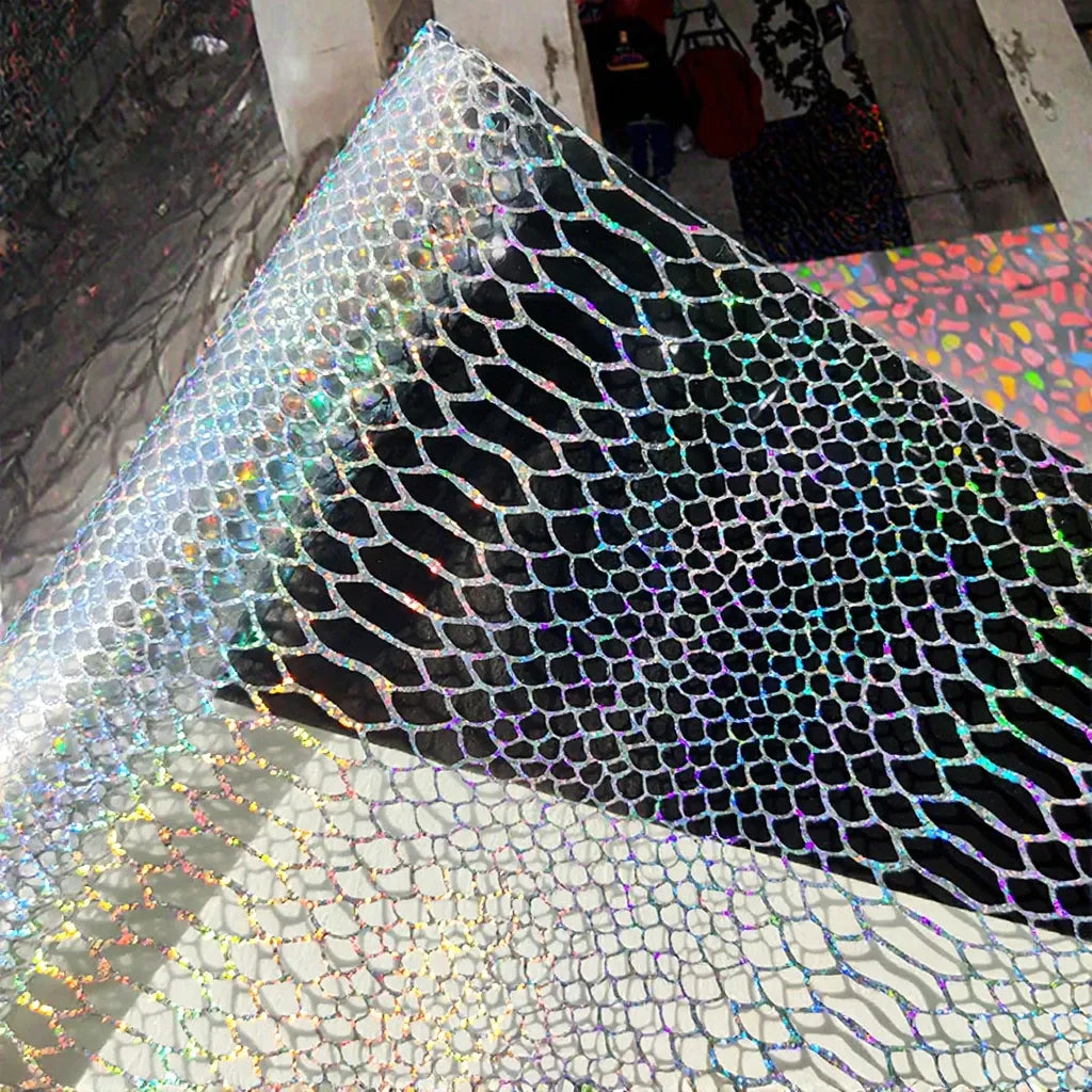Iridescent transparent PVC film sheet with dark snake-skin scale pattern.