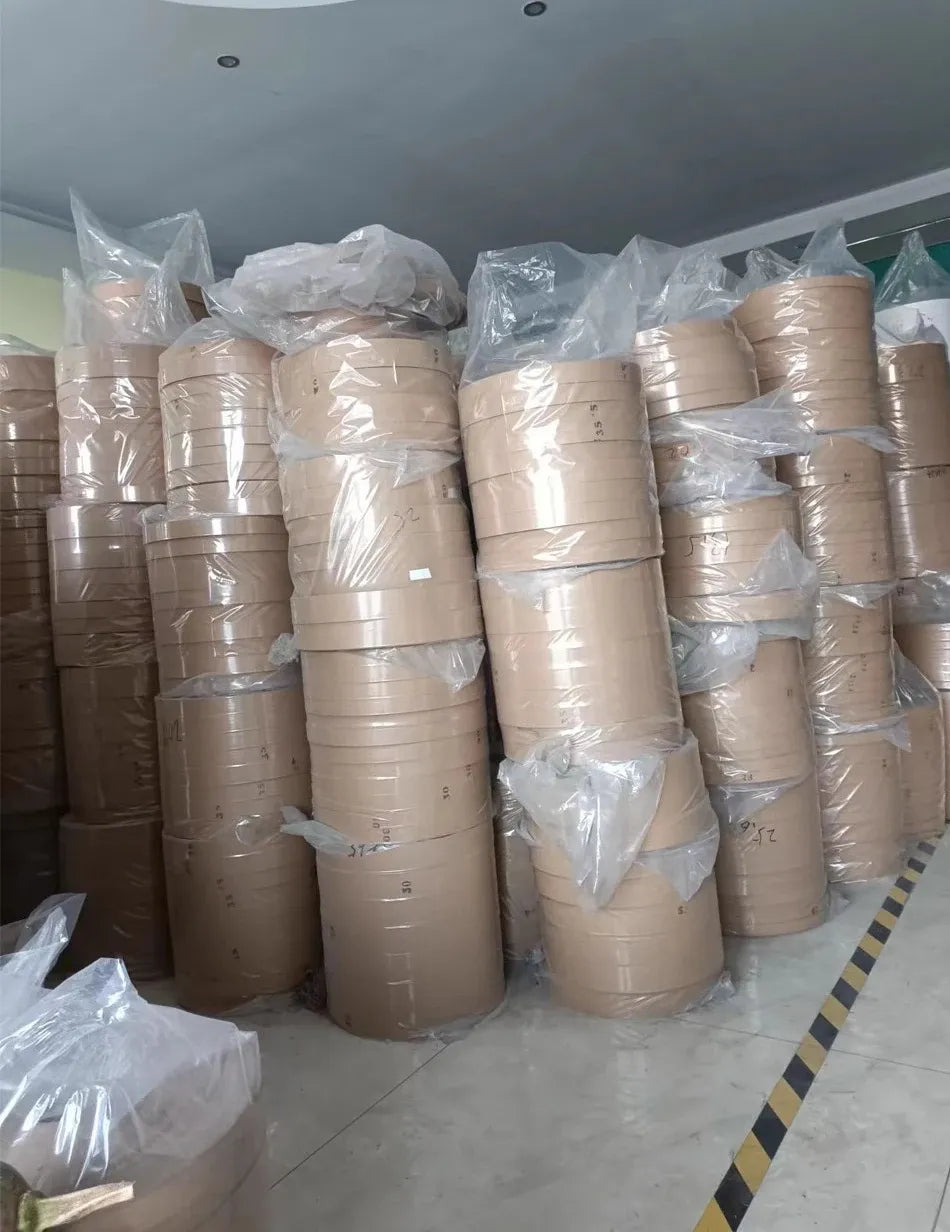 Stacked brown-tan kraft shipping tape rolls wrapped in plastic