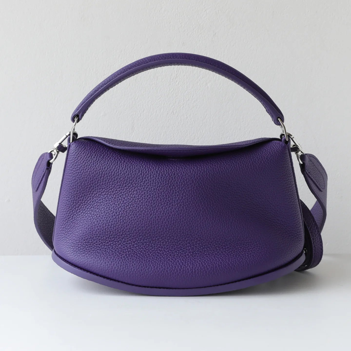 Purple pebble-grain cowhide leather designer handbag, pillow-shaped casual commuting bag with two versatile straps.