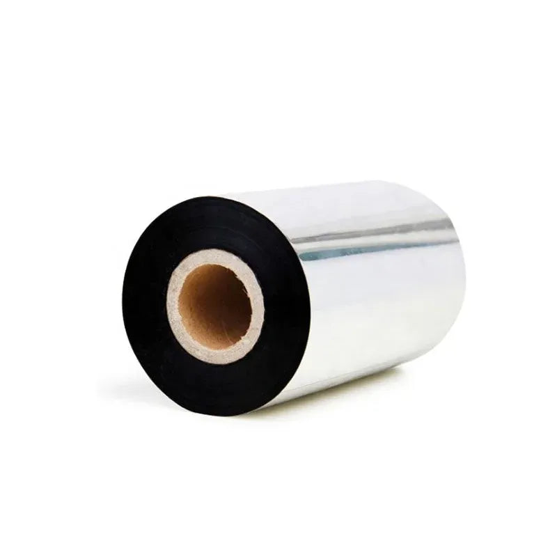 Black-and-silver thermal transfer ribbon roll on a spool, cardboard core visible.
