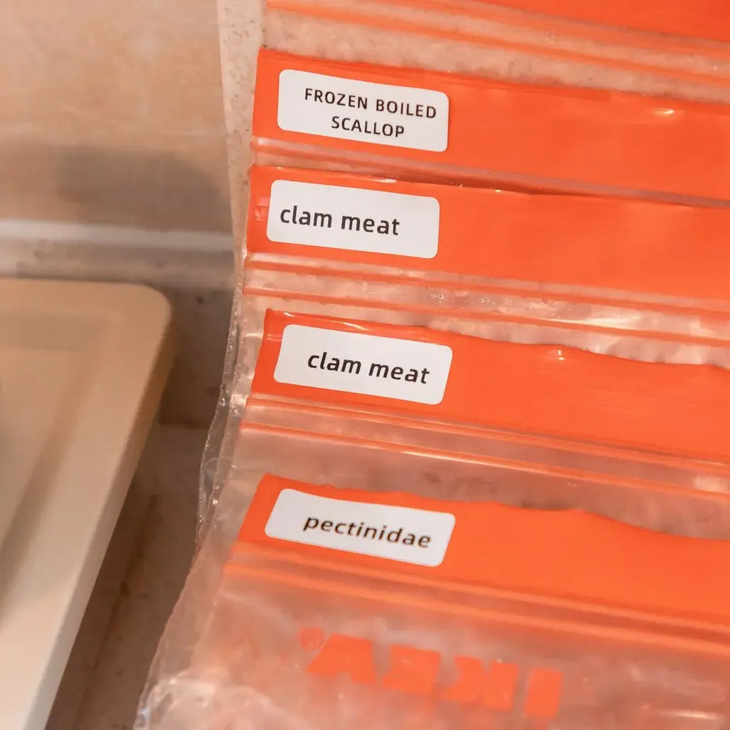 Thermal labels on orange food storage bags with printed item names