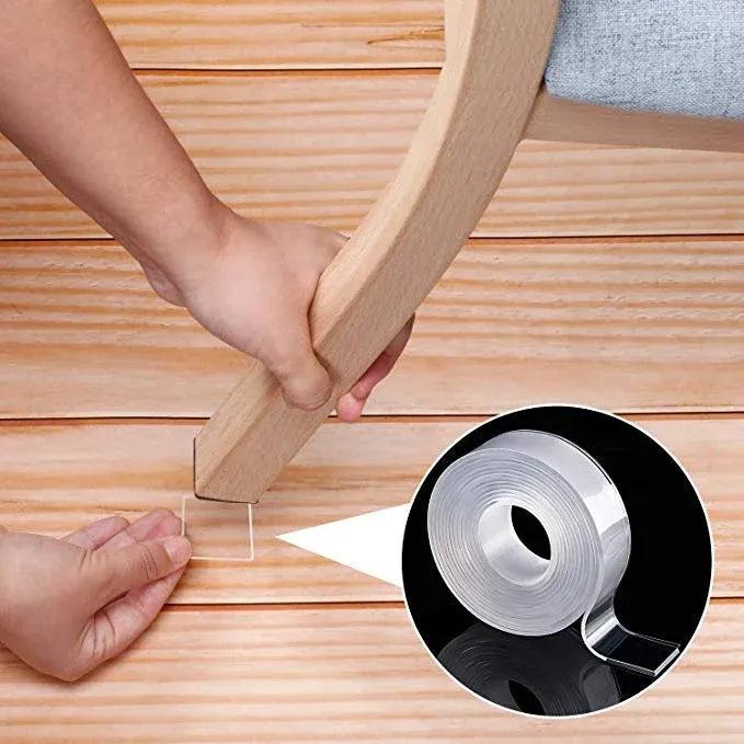 White double-sided tape applying to a wooden frame on a light wood surface