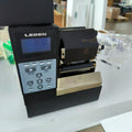 Black industrial thermal label printer with LCD screen and keypad control panel