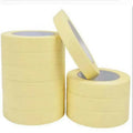 Light yellow masking tape rolls with adhesive backing, single roll and loose strip shown