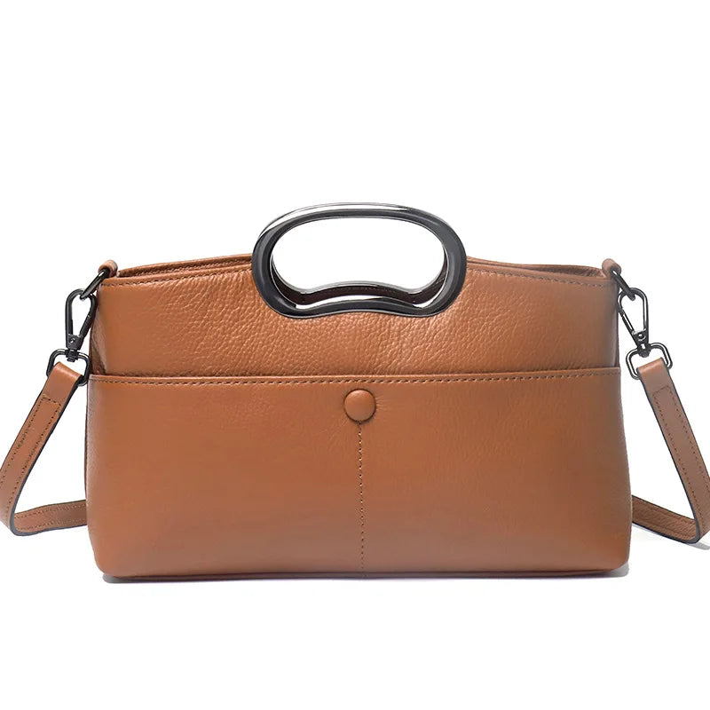Brown pebbled PU leather designer handbag with metal handle, detachable shoulder strap, and minimalist snap closure.