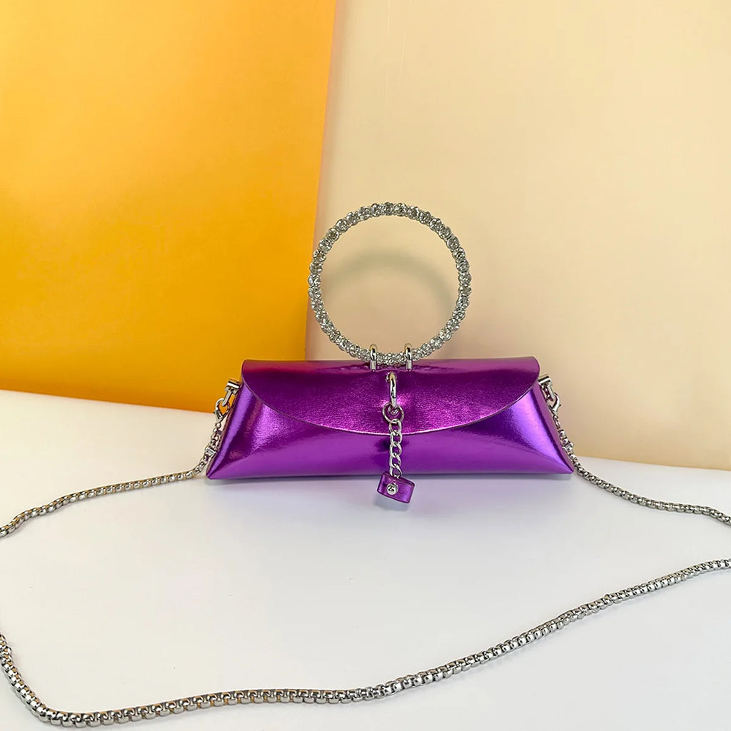 Metallic purple PU leather evening clutch with crystal ring handle, detachable silver chain, and trunk-style design.