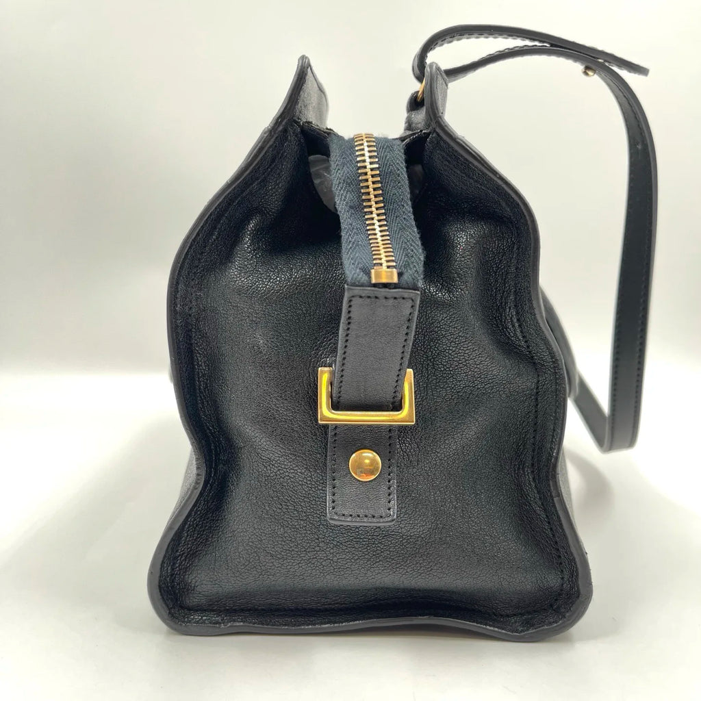 Black genuine leather designer handbag, pillow-shaped with gold hardware, top zipper, and dual straps. Retro style.