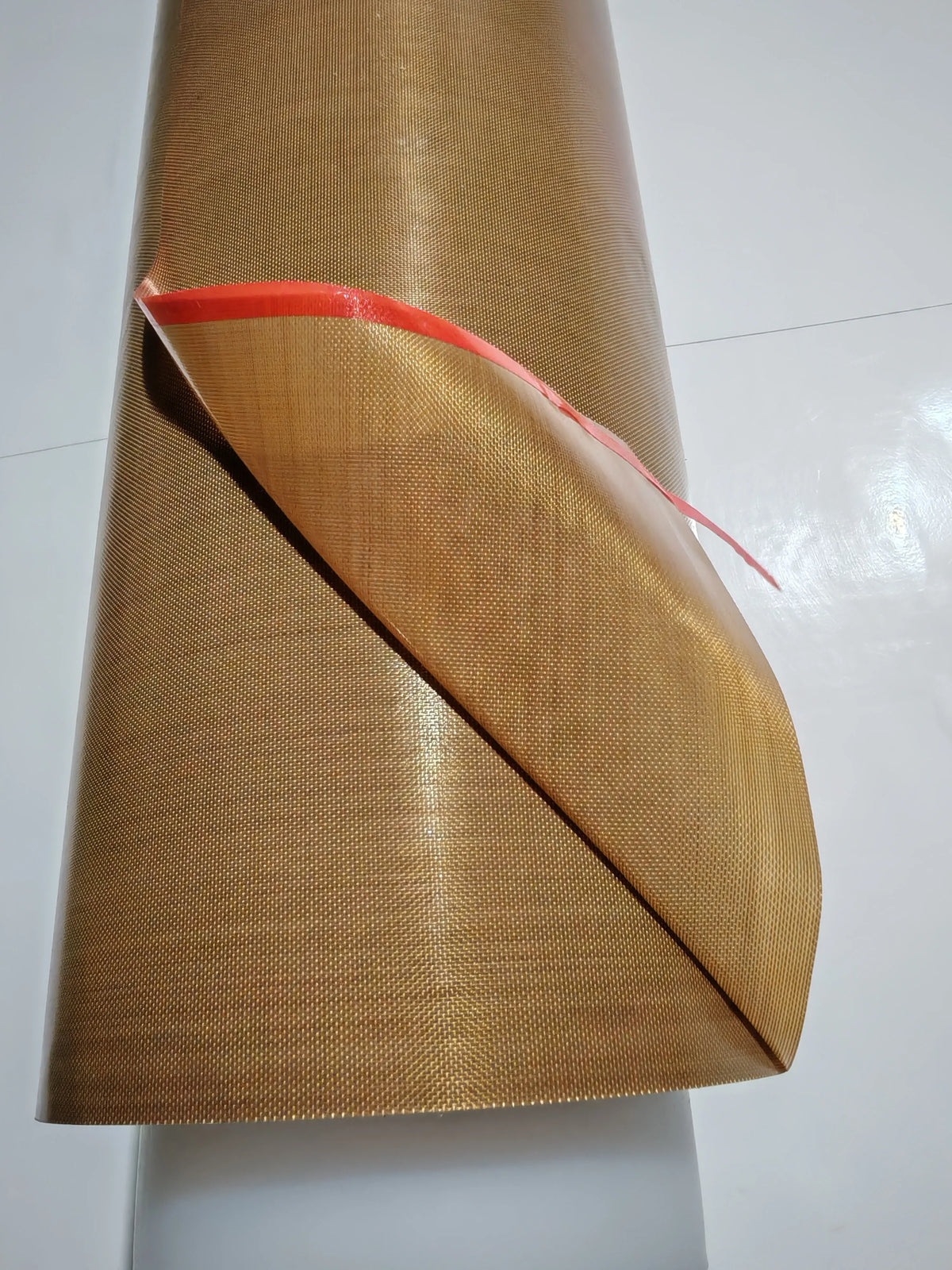 Brown PTFE tape roll with red sealing strip at the fold end