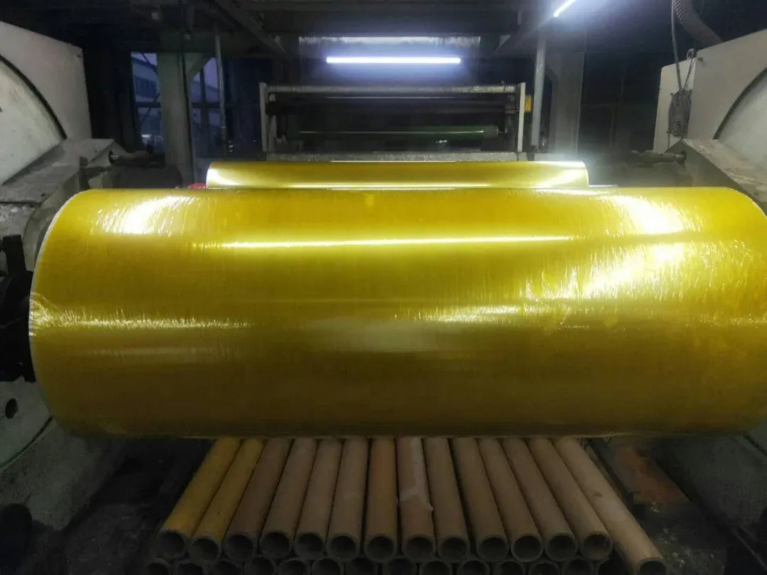 BOPP adhesive tape jumbo roll, glossy yellow roll on an industrial machine