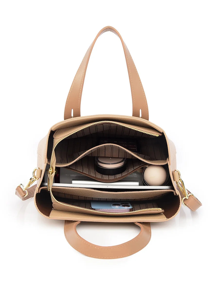 Beige leather designer handbag with a multi-compartment interior, gold zippers, and organized storage pockets.