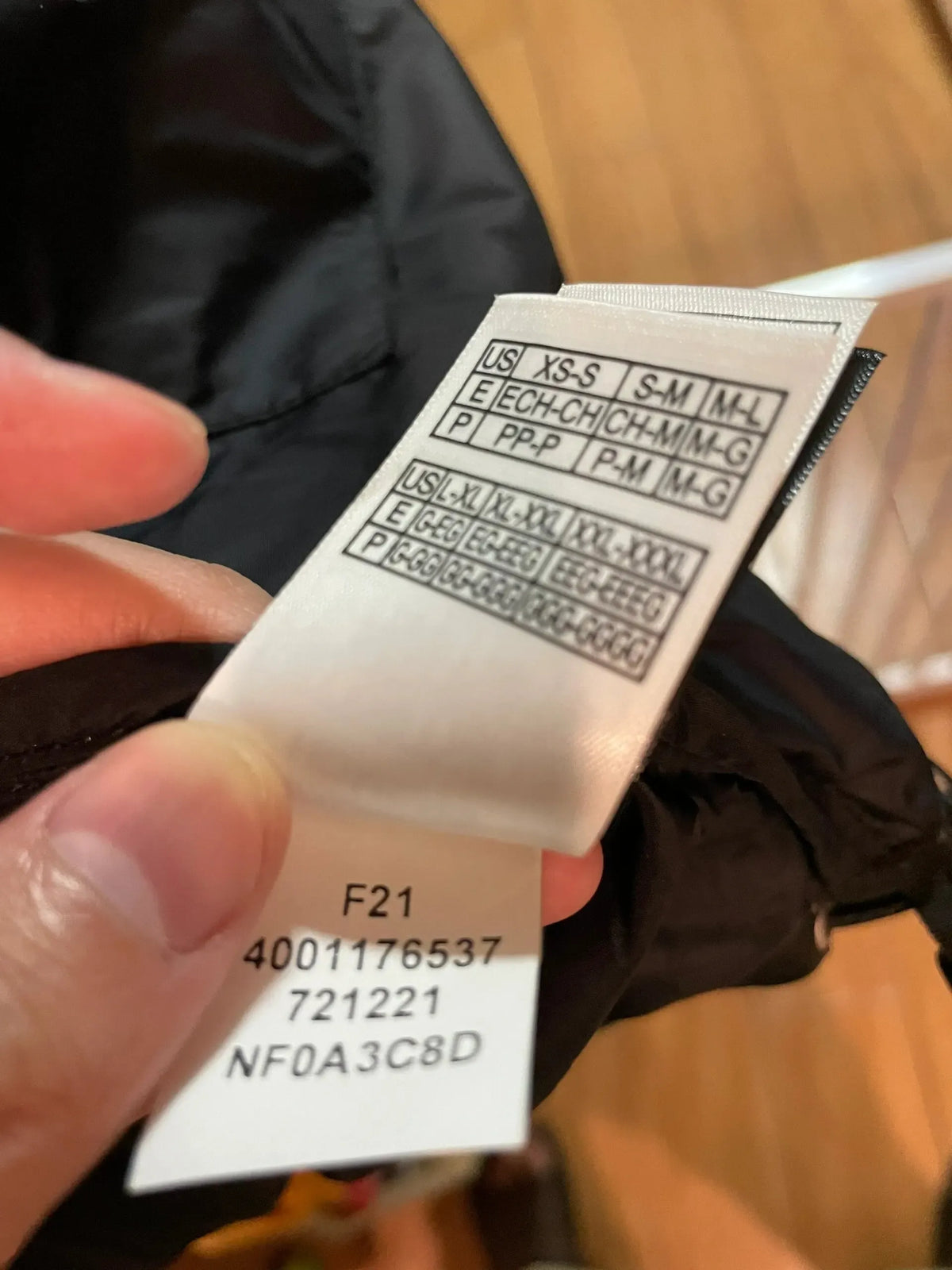 Wash care label tag close-up with barcode and sizing codes on white transfer tape