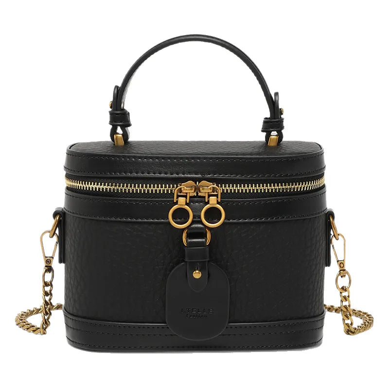 Black caviar cowhide leather vanity trunk bag with gold hardware, top handle, and detachable chain shoulder strap.