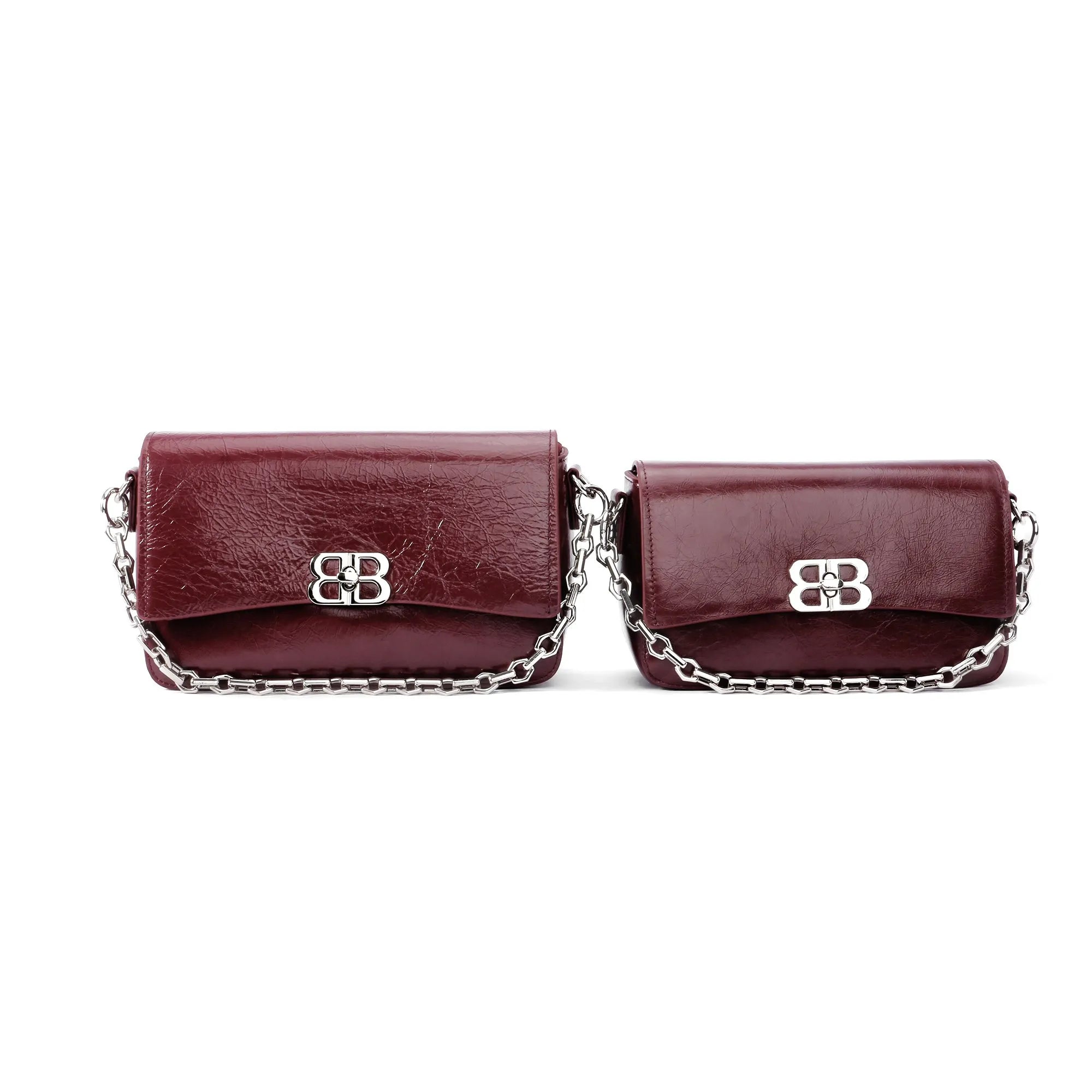 Two burgundy genuine leather designer clutch bags with silver chain straps and metallic front closure buckles.