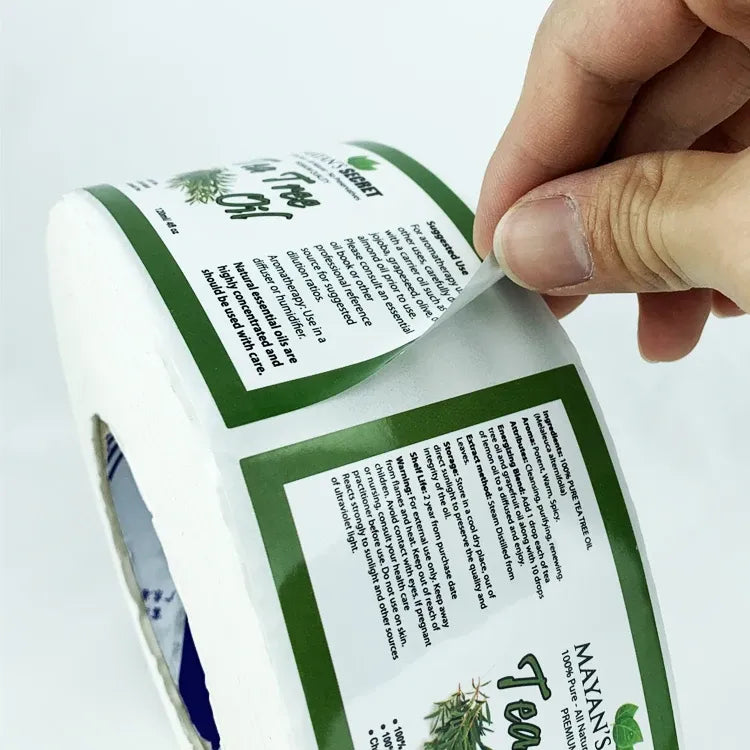 Glossy waterproof label sticker roll with green label being peeled by hand