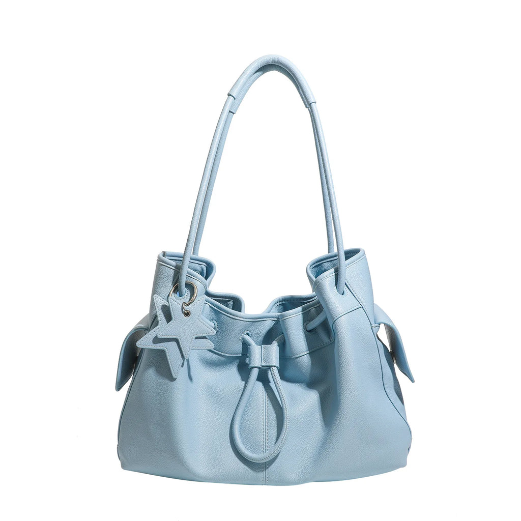 Light blue designer underarm shoulder bag with drawstring closure, two straps, and a star charm for women.