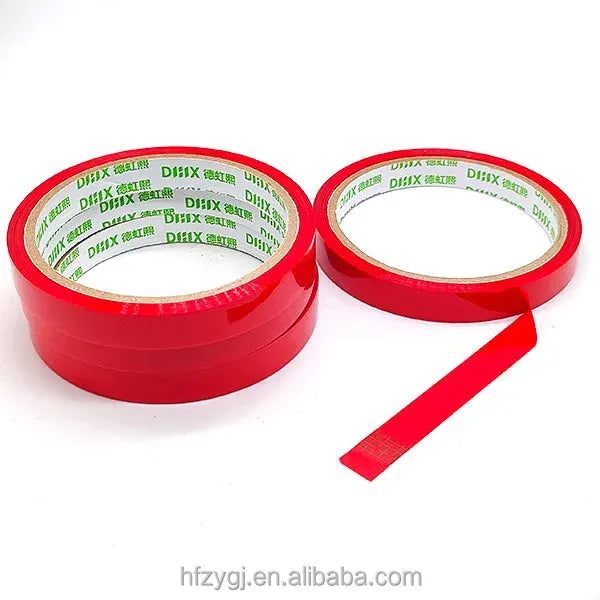 Red strapping tape rolls with one loose red strip extending outward