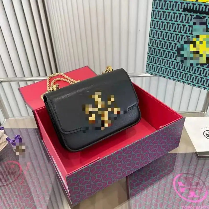 Black Zhenwo fashion trunk crossbody bag with gold metal logo, rope chain strap, and structured leather finish.