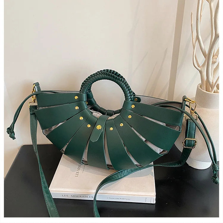 Dark green hollow-out half-moon crossbody handbag with braided round handle and gold stud accents, luxury style.