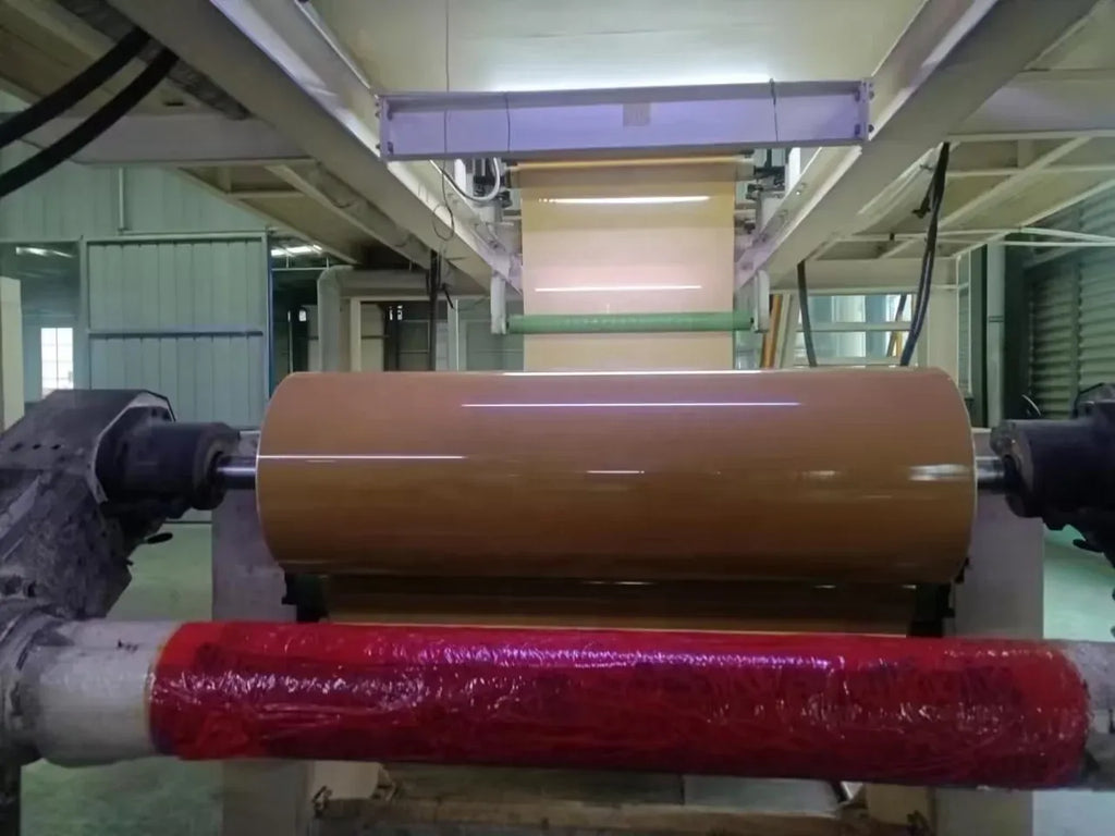 Clear BOPP tape jumbo roll mounted on processing machine rollers