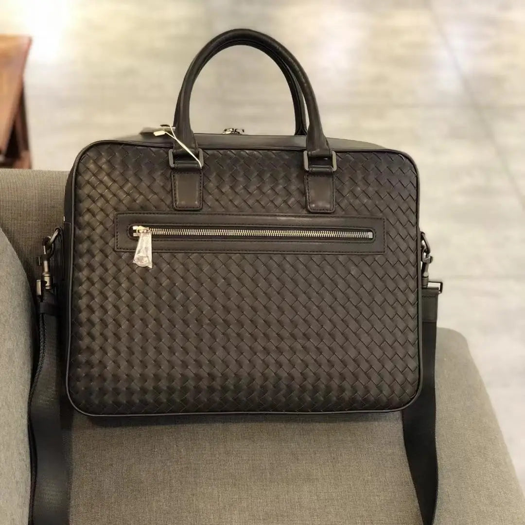 Luxury black hand-woven cowhide leather laptop briefcase for men with a zip front pocket and adjustable shoulder strap.
