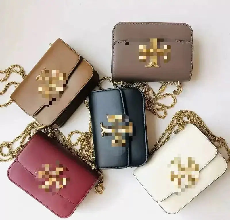 Assorted Zhenwo TB leather trunk crossbody bags with gold metal chains and signature metallic logo plaques.