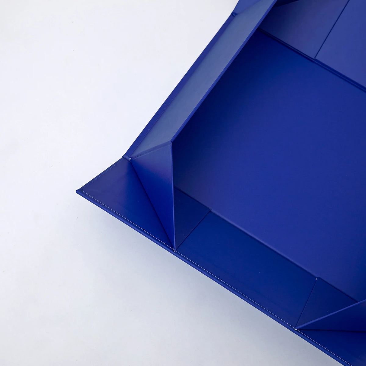 Blue corrugated mailer box with open top showing folded interior tray.