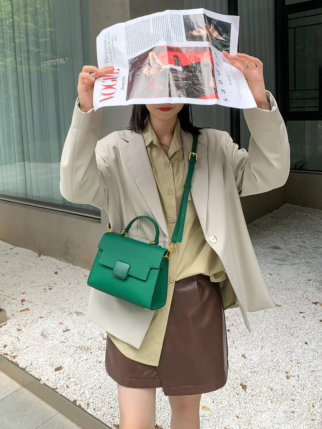 Green pebble leather designer handbag with a top handle, shoulder strap, and flap closure for women.