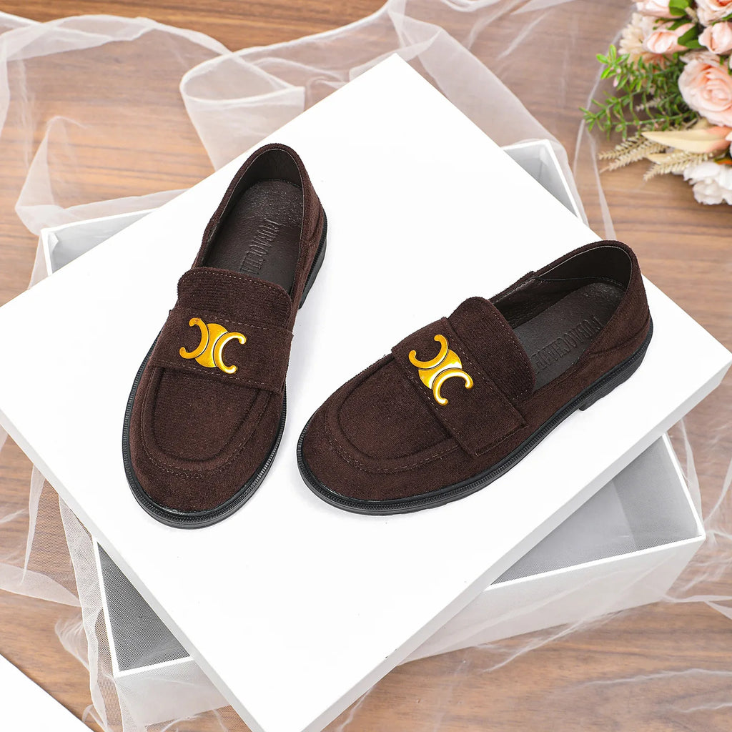 Luxury dark brown suede women's loafers with gold metallic logo emblem and durable black rubber lug soles.
