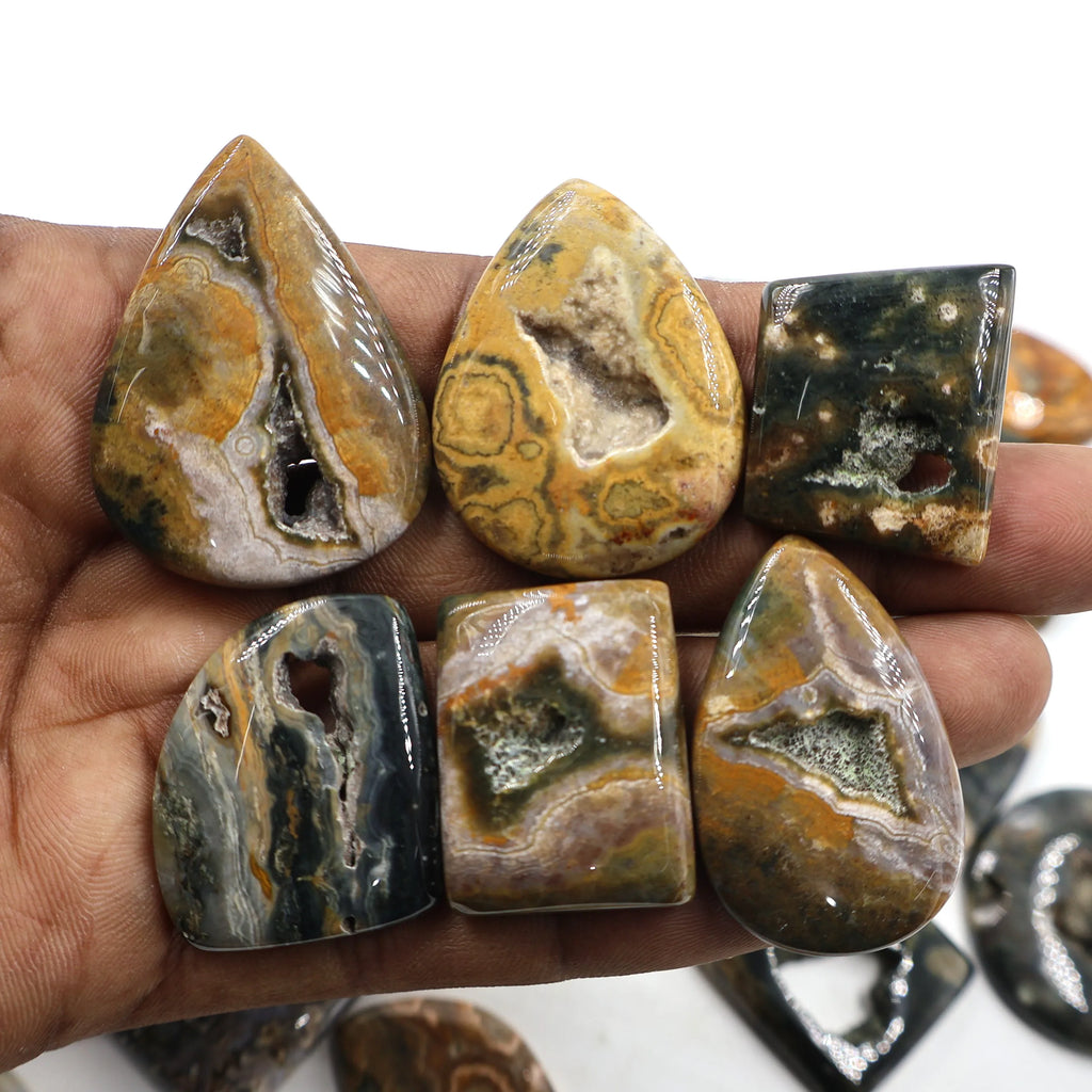 Handful of ocean jasper druzy cabochons, oval and rectangular stones with earth-tone swirls