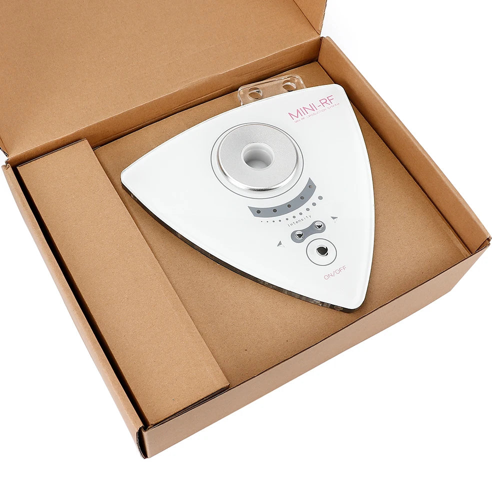 White triangular 3-in-1 RF skin lifting device with intensity controls, nestled in a brown cardboard box.