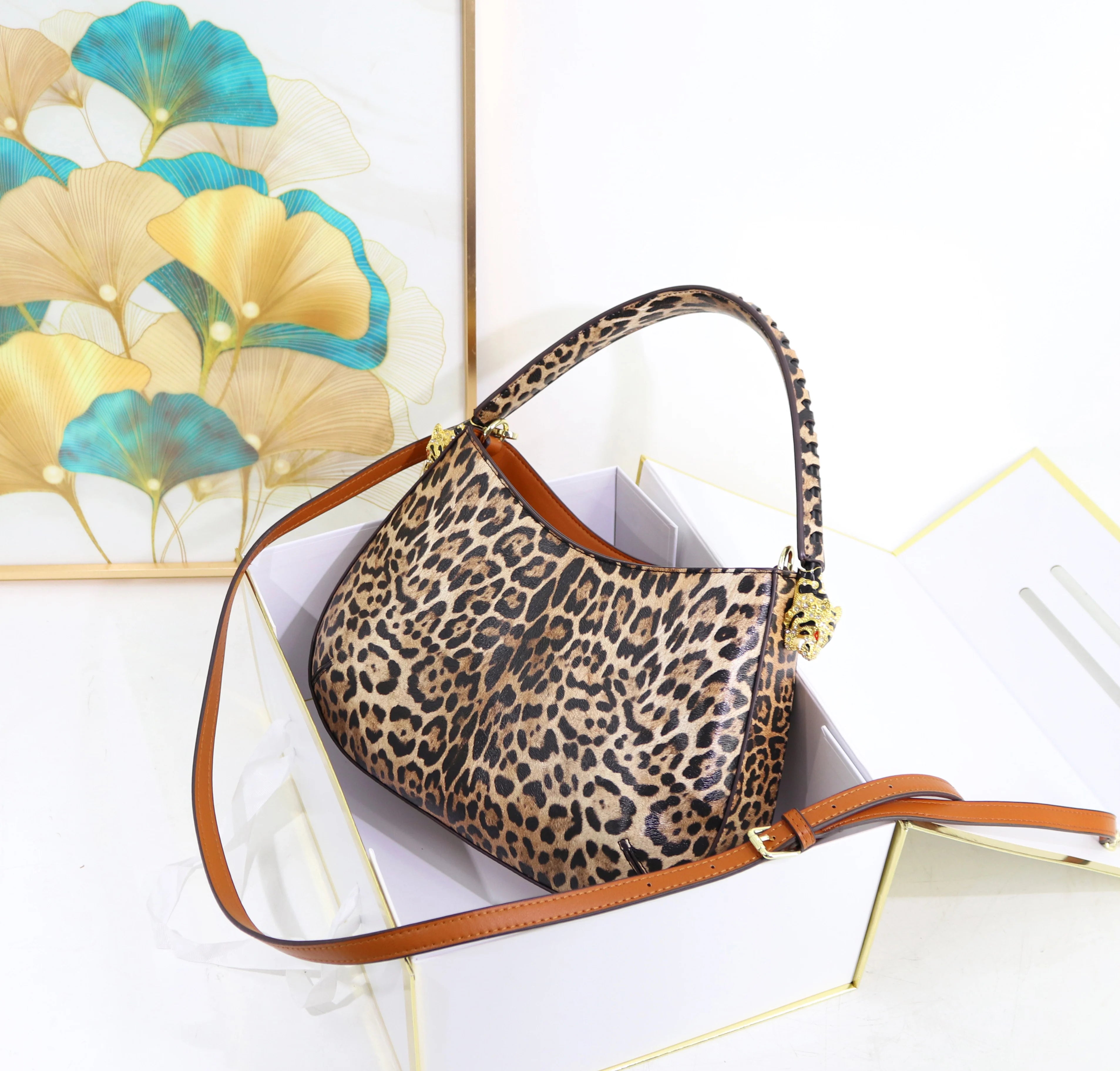32cm leopard print designer shoulder bag with tan leather straps and gold metal accents in a gift box.