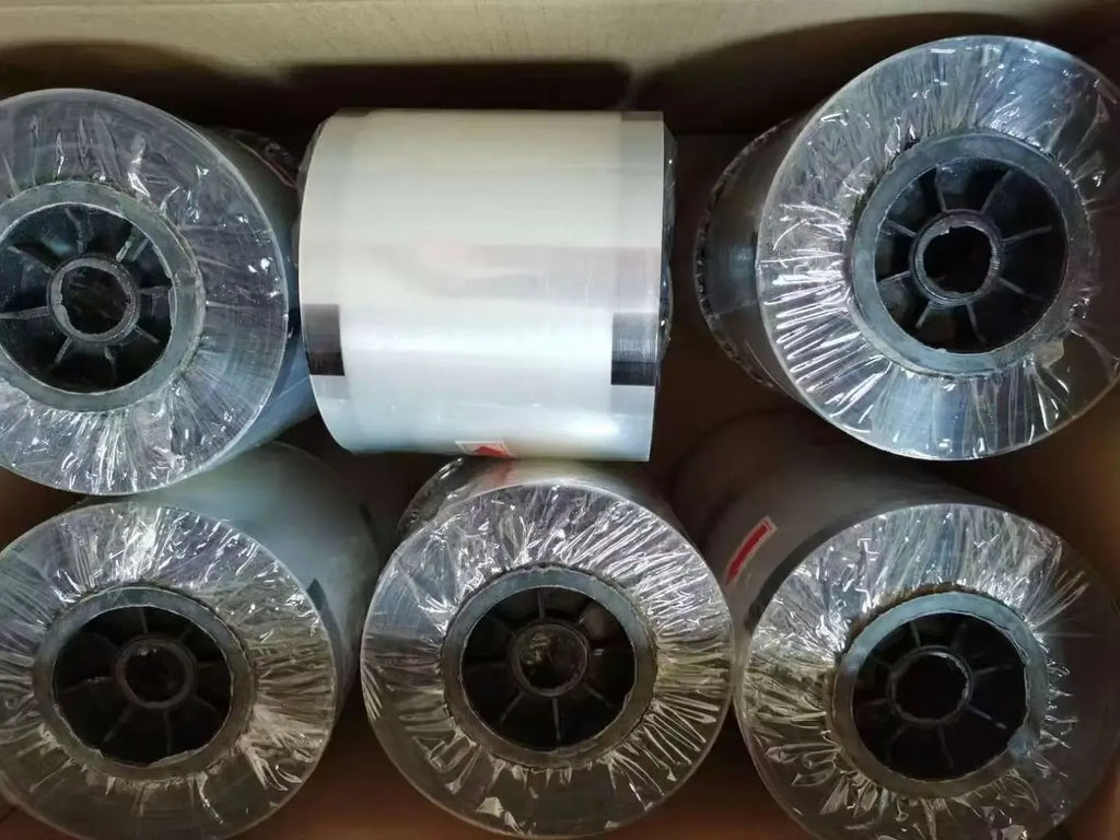 Stack of clear plastic film rolls wrapped in protective plastic packaging