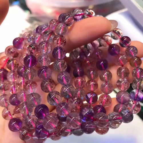 Purple rutilated quartz bead stretch bracelet with round faceted super seven style beads