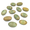 Set of green and yellow oval crystal pebbles, smooth luminous landscaping stones