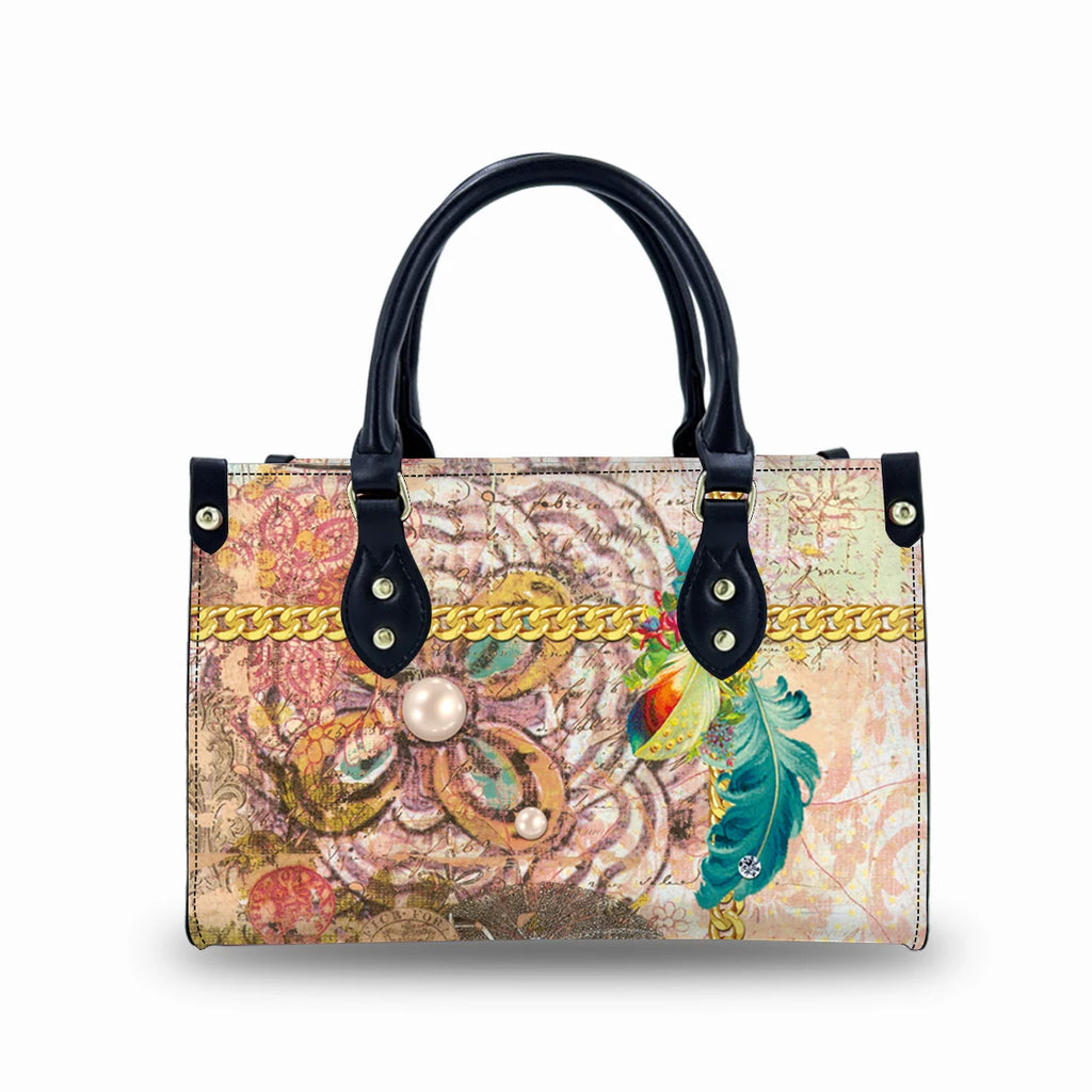 Vintage leather trunk handbag with colorful floral print, gold chain detail, pearls, and black dual handles.