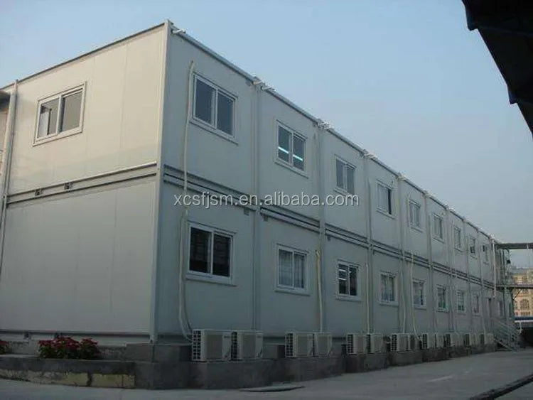 Multi-story modular container trunk building with white metal panels, rectangular windows, and external HVAC units.
