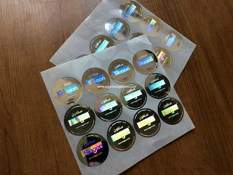 Round holographic adhesive stickers on PET sheet, mostly silver with a few black circles